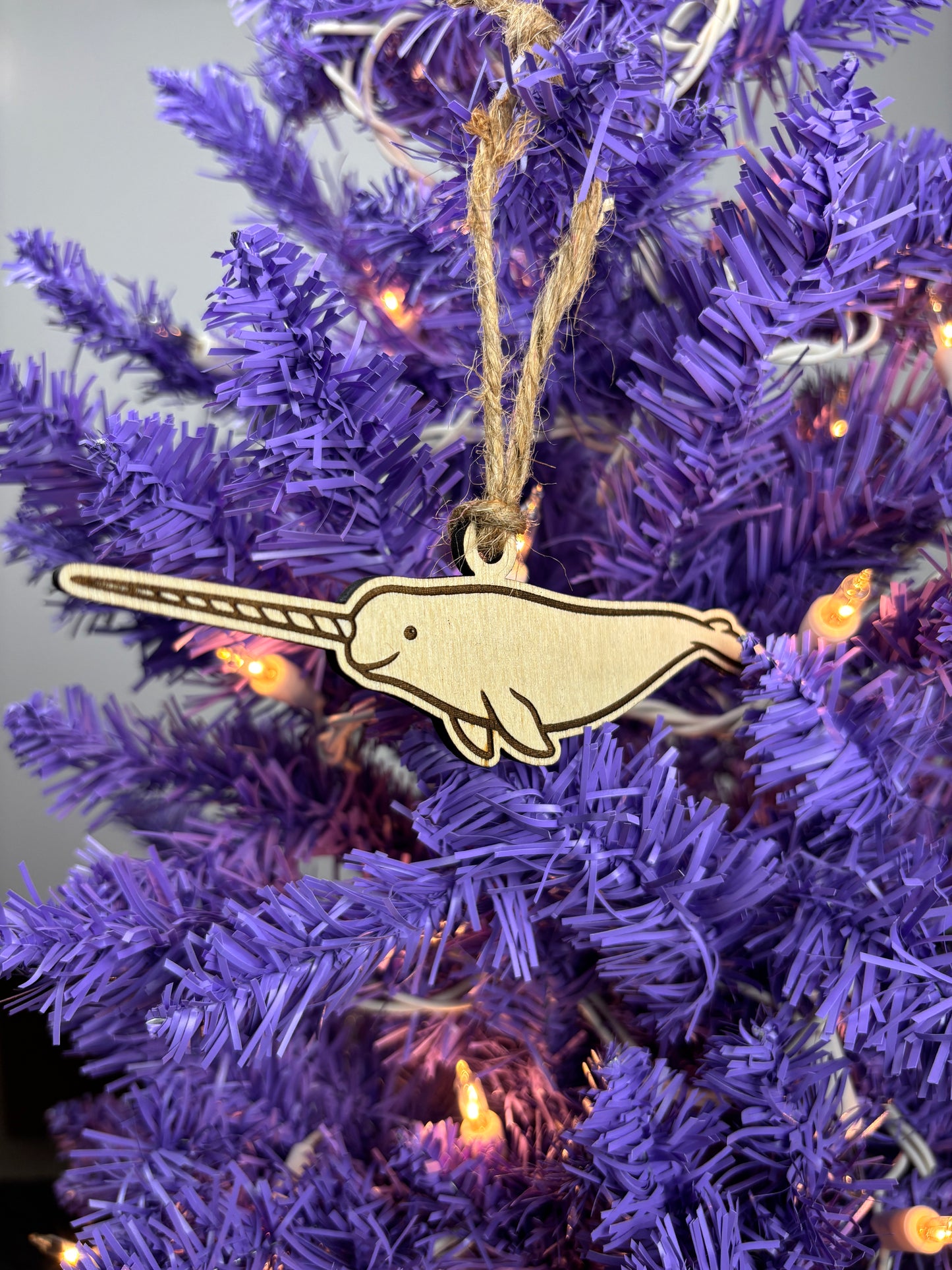 Wooden narwhal ornament on a purple Christmas tree