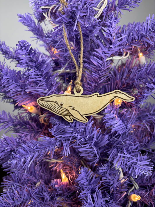 Decorative whale ornament on a purple Christmas tree with lights