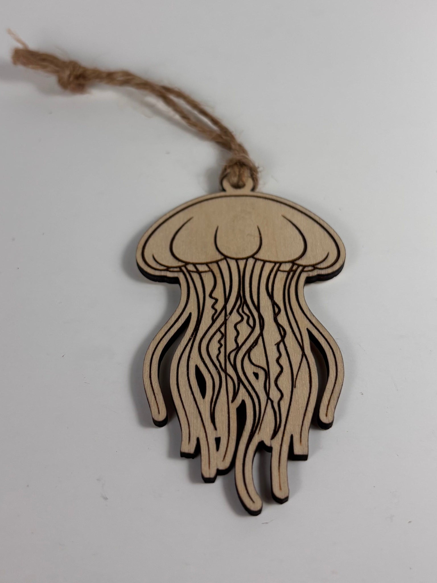 Wooden jellyfish ornament with string on a white background
