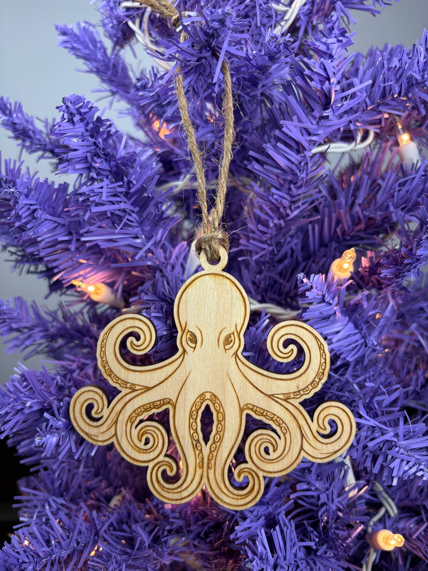 Decorative wooden octopus ornament on a purple Christmas tree.